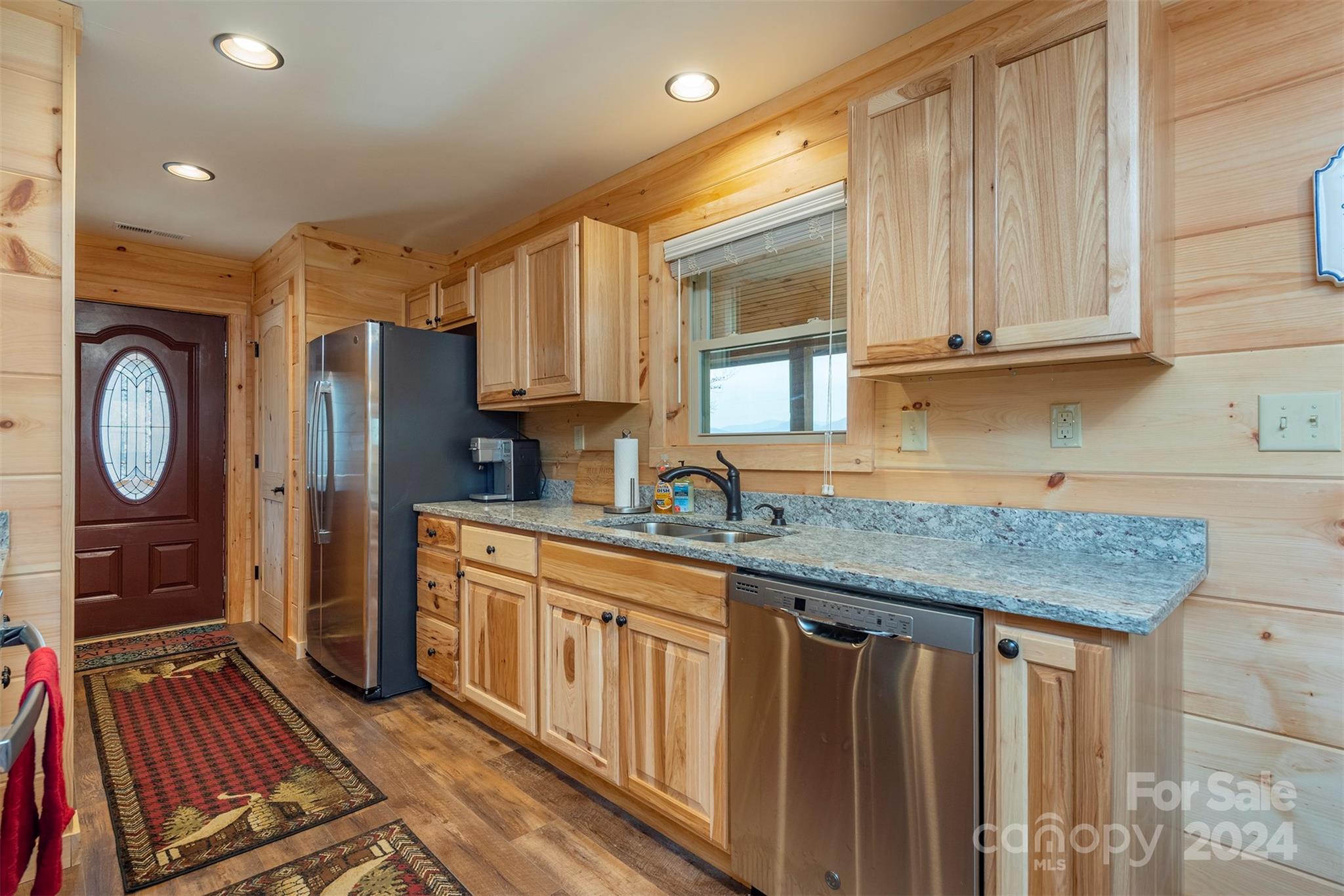 4125 Old Greenlee Road Marion, NC 28752 - Photo 16 of 48 a kitchen with stainless steel appliances granite countertop a refrigerator a sink dishwasher and wooden cabinets with wooden floor