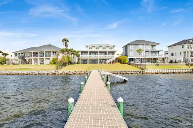 a front view of a building with a garden and parking space