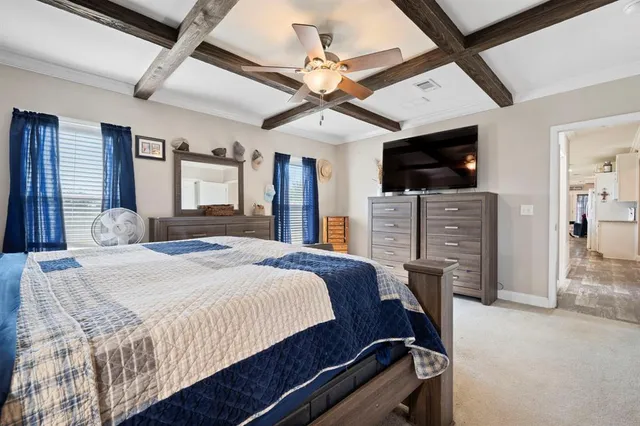 a spacious bedroom with a bed a flat screen tv and a dresser