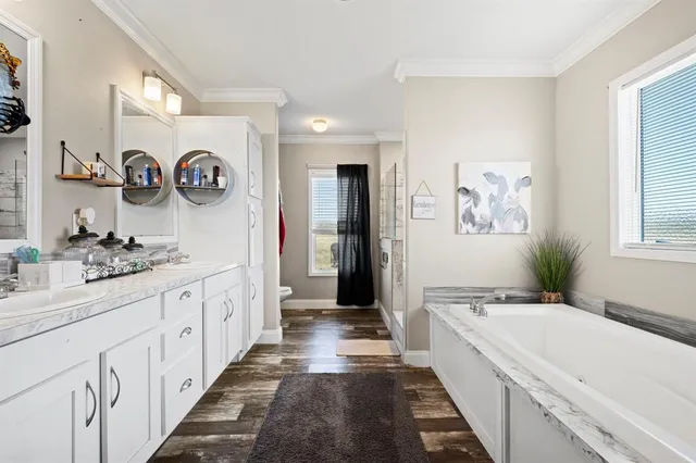 a large bathroom with a granite countertop double vanity sink a mirror and a bathtub