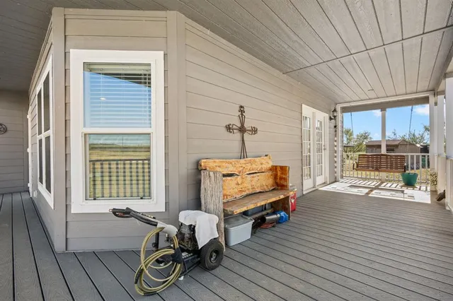 a living room with furniture a flat screen tv and floor to ceiling window