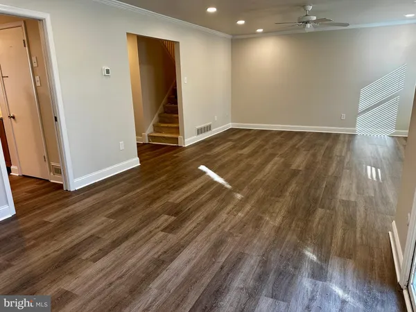 a view of a room that has a large window and wooden floor