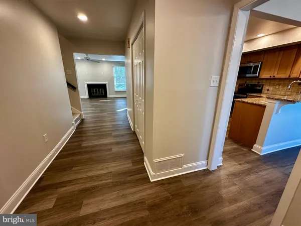 a kitchen with stainless steel appliances granite countertop a sink cabinets and wooden floor