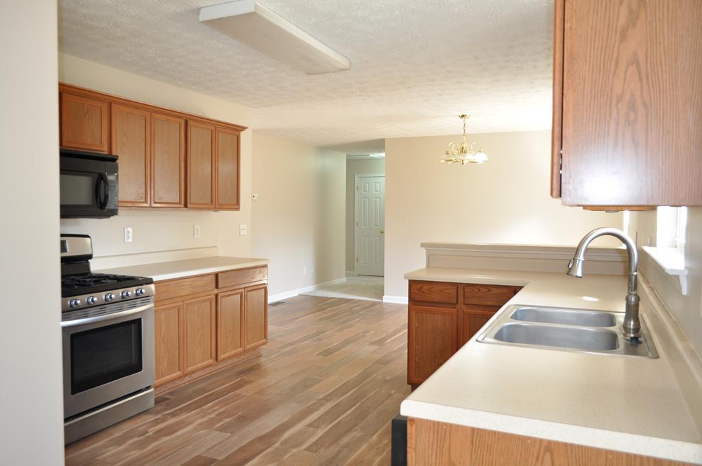 142 Old Indian Springs Road Forsyth, GA 31029 - Photo 18 of 30 a kitchen with stainless steel appliances granite countertop a stove a sink and a refrigerator