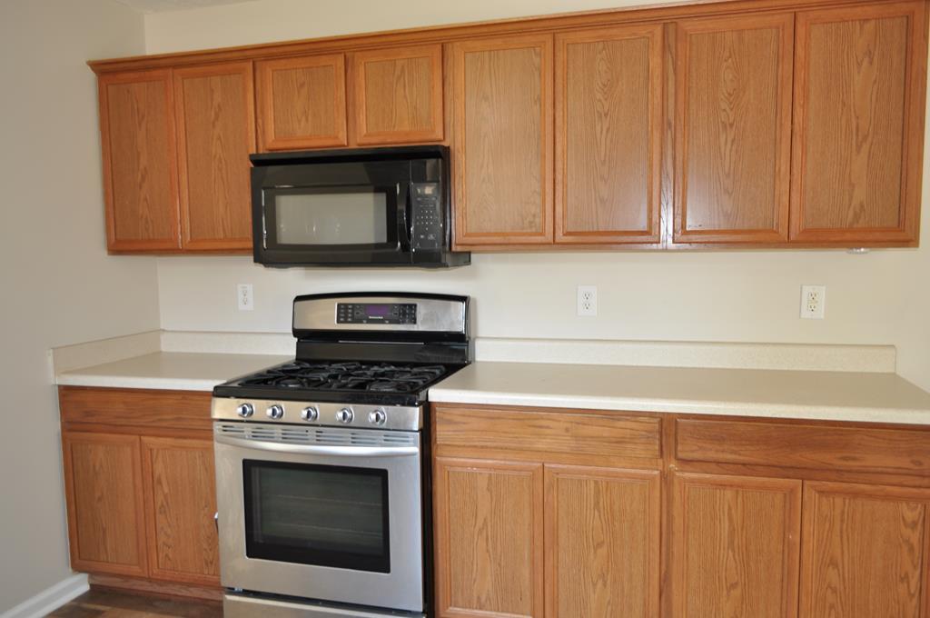 142 Old Indian Springs Road Forsyth, GA 31029 - Photo 6 of 30 a kitchen with granite countertop white cabinets and stainless steel appliances