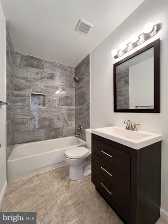 a bathroom with a toilet a sink a mirror a bathtub and shower