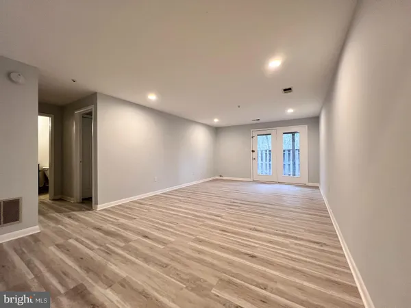 a view of empty room with wooden floor