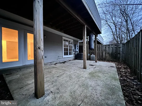 a view of an empty room with wooden floor and windows