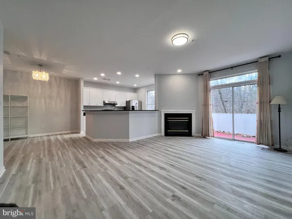 a view of a big room with wooden floor and a kitchen