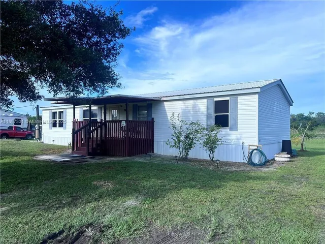 a view of a house with a yard and sitting area