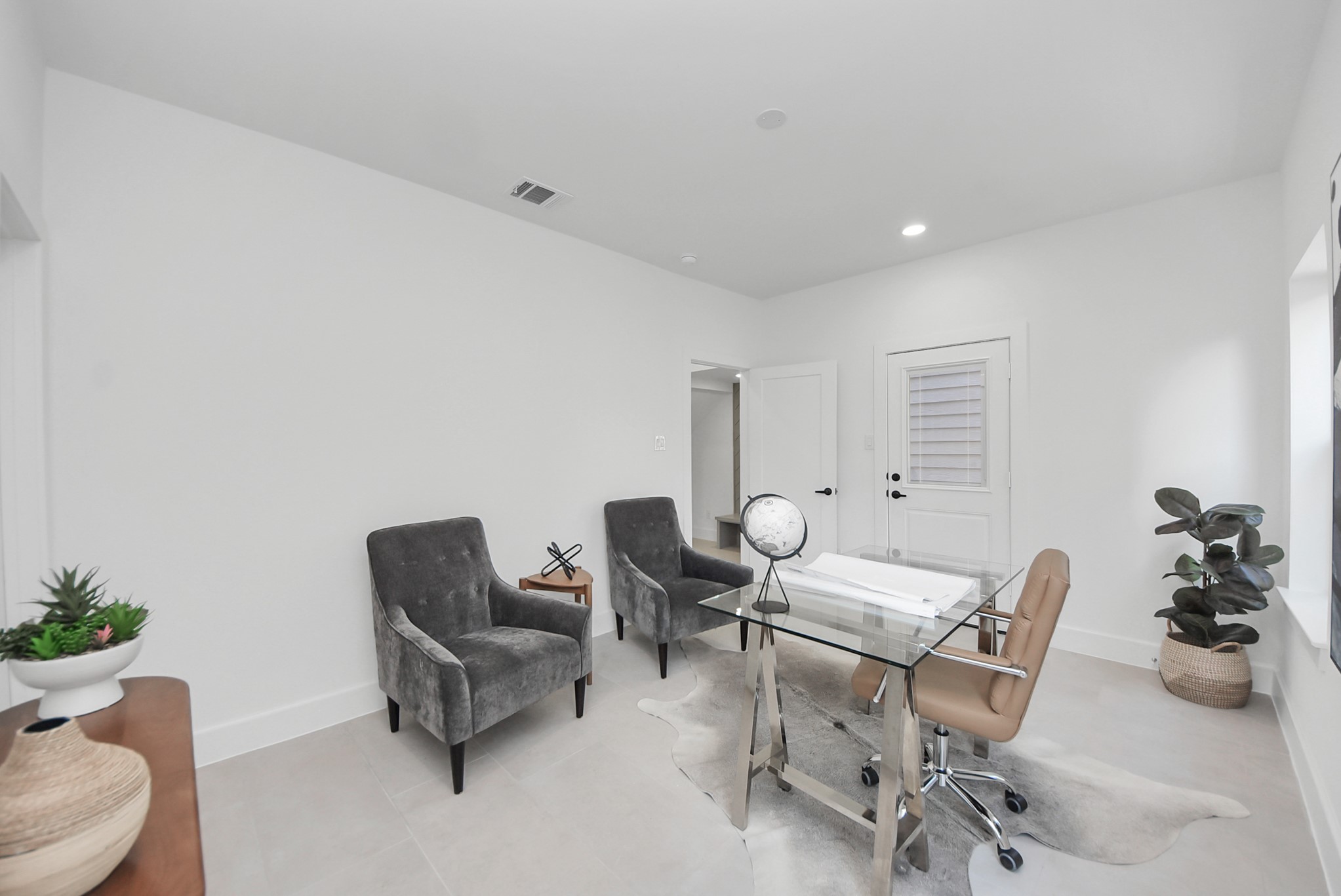 925 Fisher Street, Unit E Houston, TX 77018 - Photo 8 of 47 A dedicated home office completes the home, offering a clean, modern workspace with white walls, oversized windows, and contemporary furnishings. A glass-top desk and bold abstract artwork add a refined touch, making this room as inspiring as it is functional.