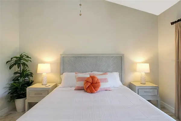 a bedroom with a bed lamp and a potted plant