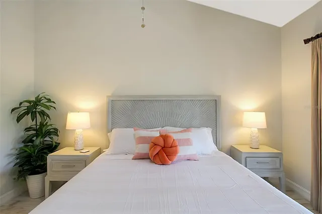 a bedroom with a bed lamp and a potted plant