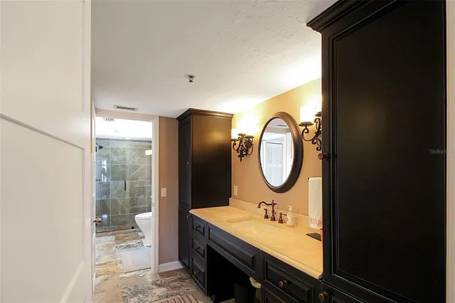 a bathroom with a granite countertop sink and a mirror
