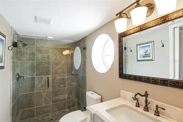 a bathroom with a sink mirror and toilet