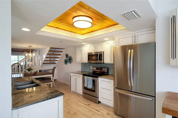 a kitchen with stainless steel appliances granite countertop a refrigerator a stove and a sink