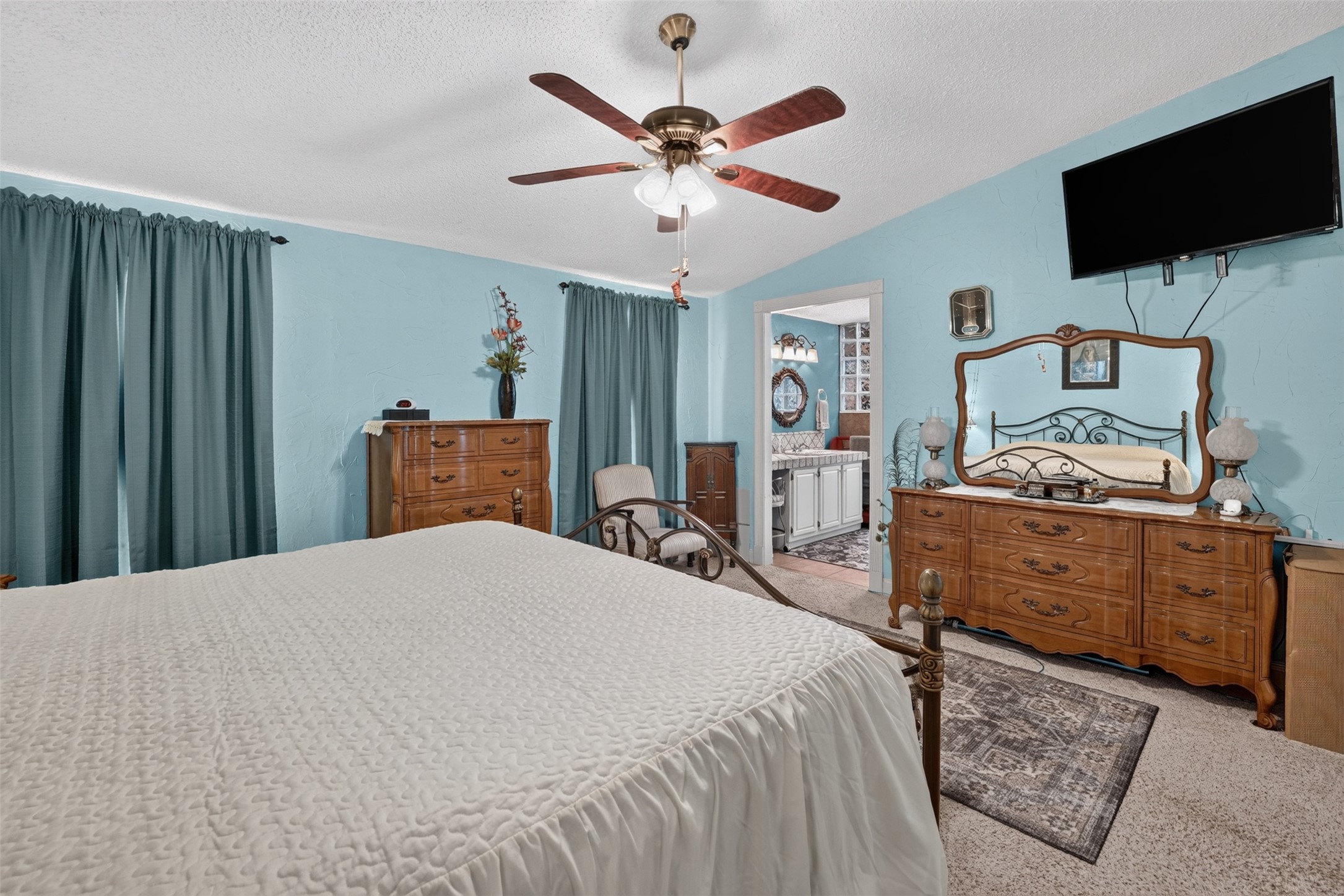 317 Rae Lane Jarrell, TX 76537 - Photo 36 of 40 A comforting bedroom features a ceiling fan, plush carpeting, and direct access to an attached private bath.
