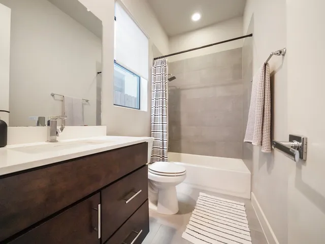 a bathroom with a sink a toilet a mirror and shower