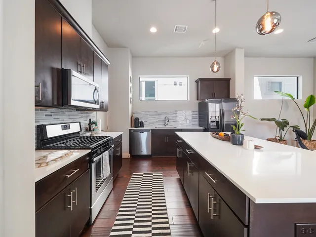 a kitchen with stainless steel appliances a sink stove and cabinets