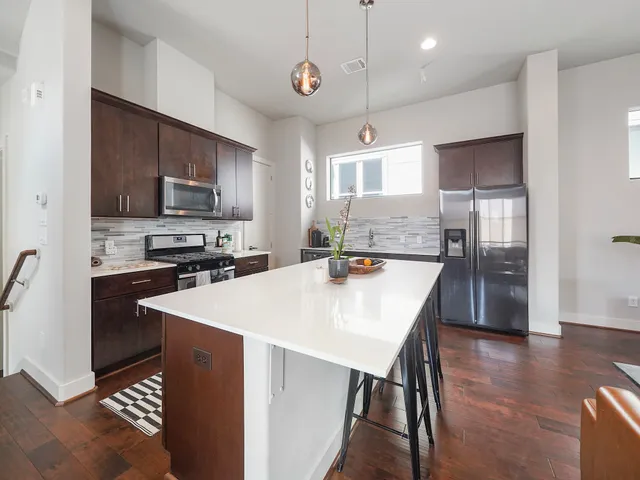 a kitchen with kitchen island a refrigerator stove microwave and cabinets