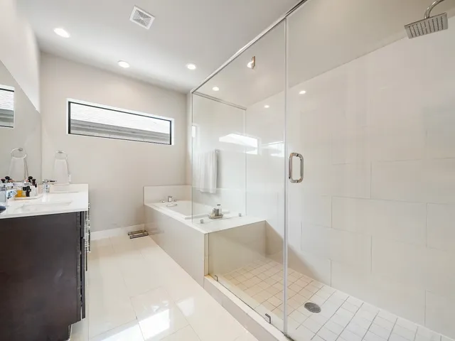 a bathroom with a tub sink mirror and shower