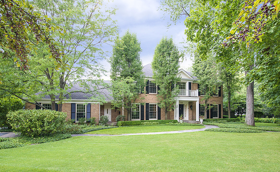 front view of a brick house with a yard