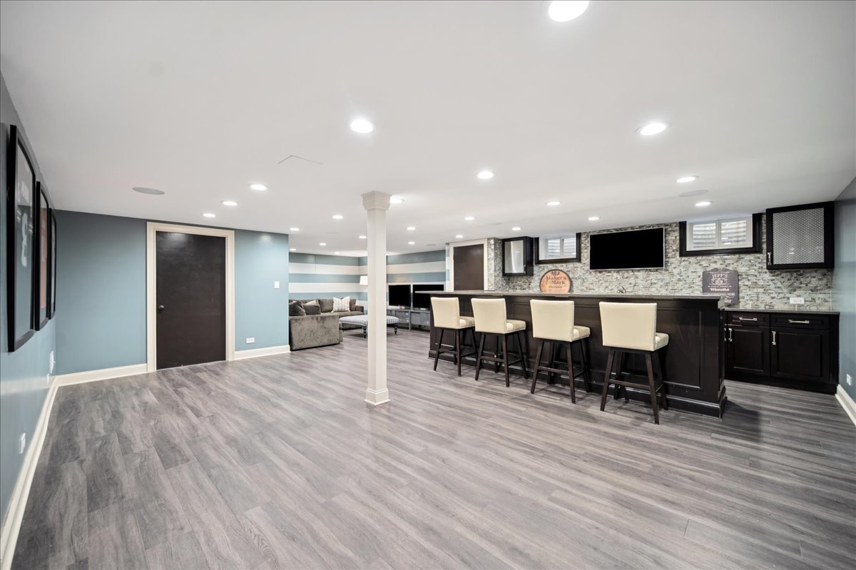 Undisclosed Address Winnetka, IL 60093 - Photo 41 of 55 a large kitchen with stainless steel appliances refrigerator a dining table chairs and stove top oven with wooden floor