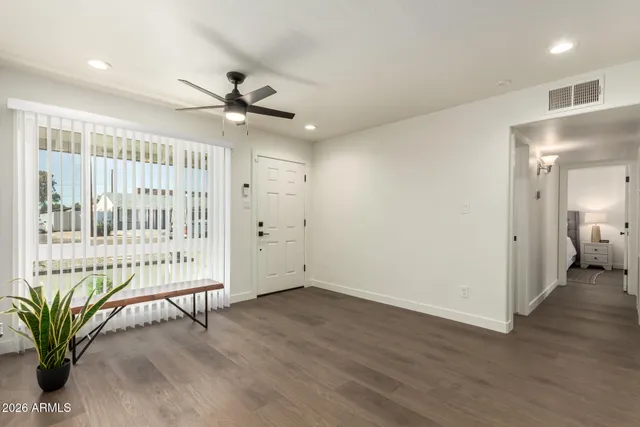 an empty room with wooden floor and windows