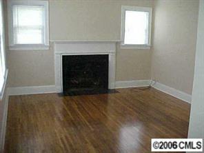 3716 Tuckaseegee Road, Unit A&B Charlotte, NC 28208 - Photo 2 of 8 an empty room with wooden floor fireplace and windows