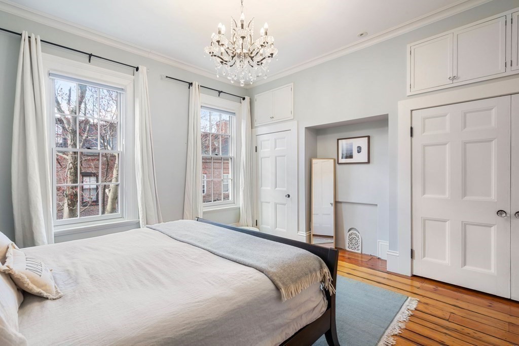 12 Cedar Street Boston, MA 02129 - Photo 15 of 23 a bedroom with a large bed and a chandelier