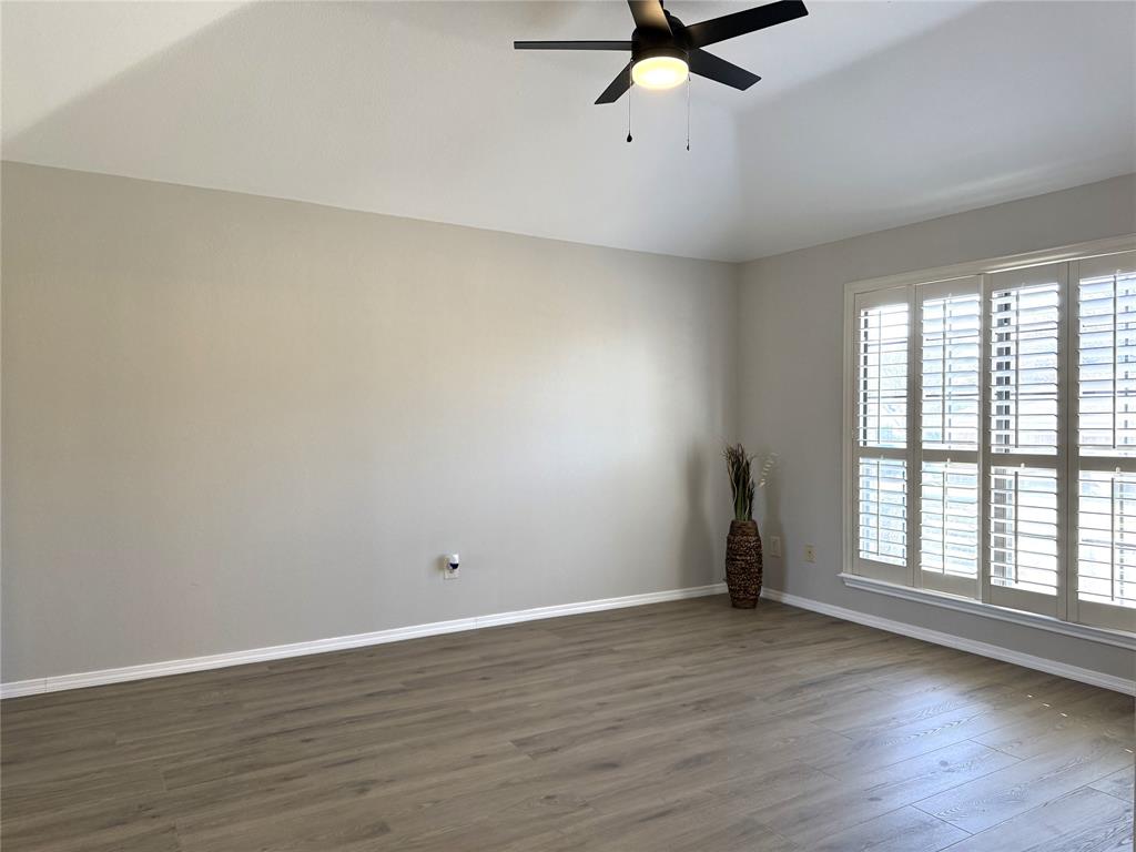 652 Harrison Drive Coppell, TX 75019 - Photo 14 of 26 an empty room with wooden floor fan and windows