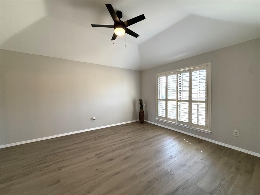 652 Harrison Drive Coppell, TX 75019 - Photo 17 of 26 an empty room with wooden floor fan and windows
