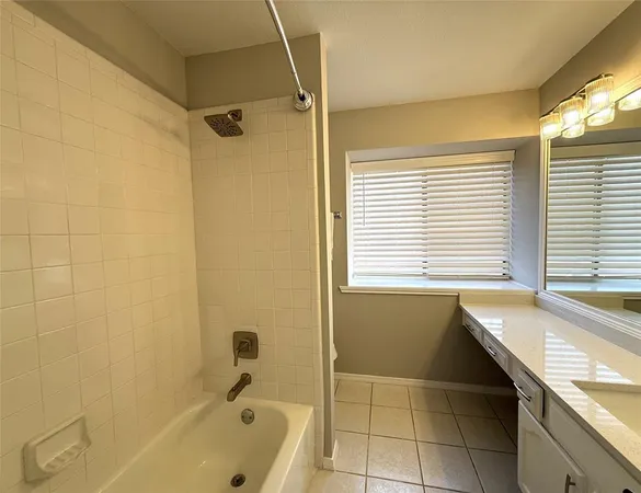 a bathroom with a granite countertop sink and a bathtub