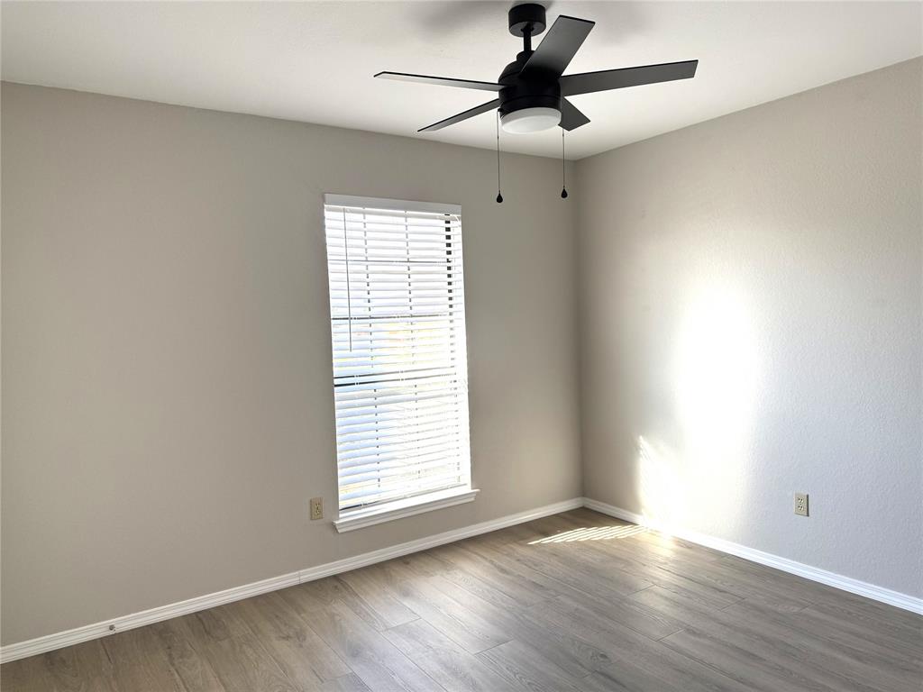 652 Harrison Drive Coppell, TX 75019 - Photo 22 of 26 an empty room with wooden floor fan and windows