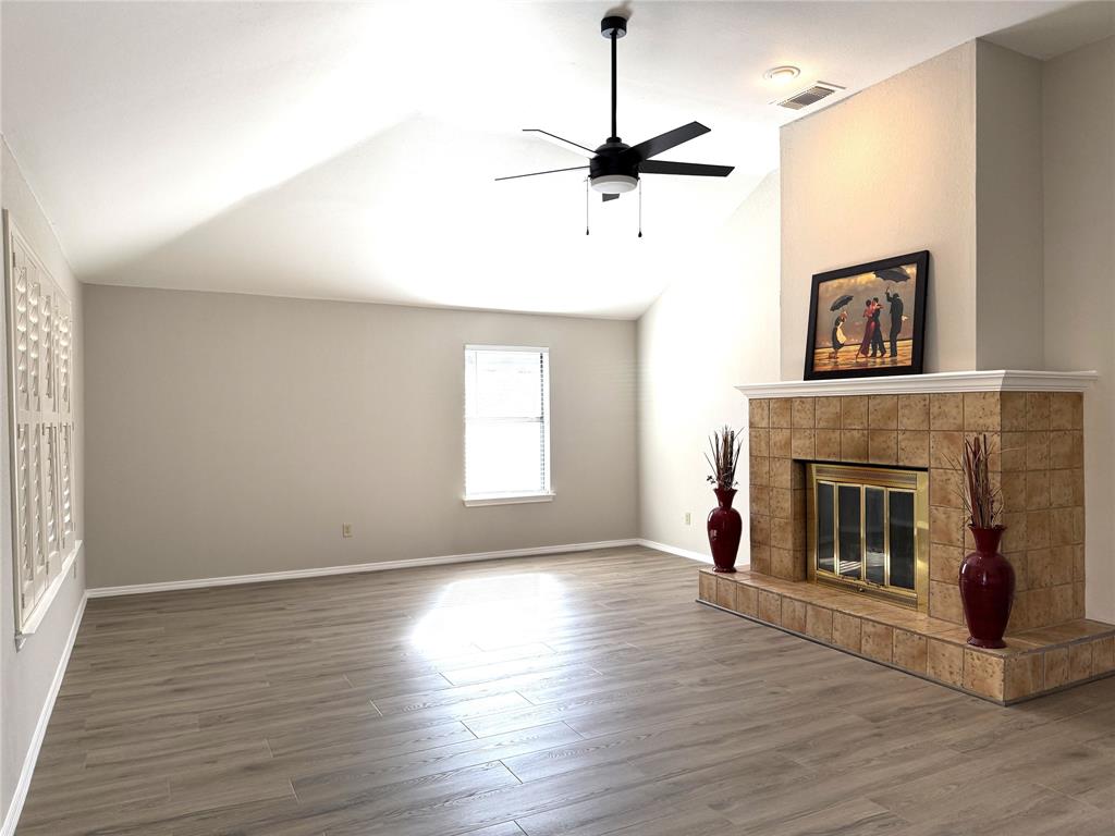 652 Harrison Drive Coppell, TX 75019 - Photo 7 of 26 a living room with wooden floor a fireplace and window