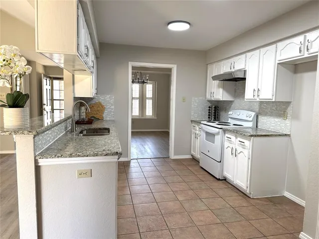 a kitchen with stainless steel appliances granite countertop a sink stove and cabinets