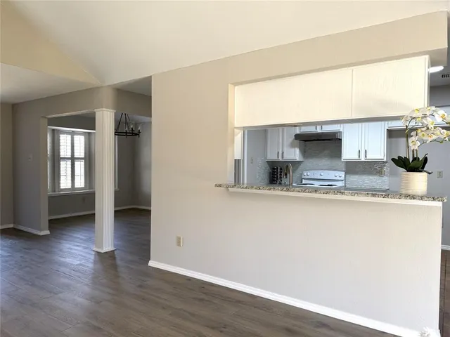 a kitchen with stainless steel appliances granite countertop a sink window and cabinets