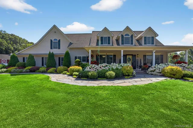 a front view of a house with a yard and potted plants