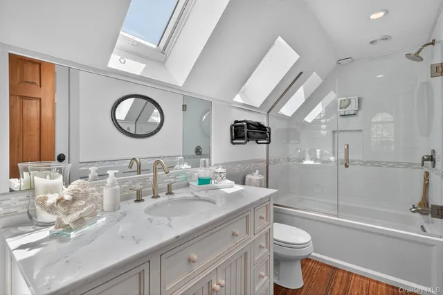 a bathroom with a granite countertop sink mirror vanity and toilet
