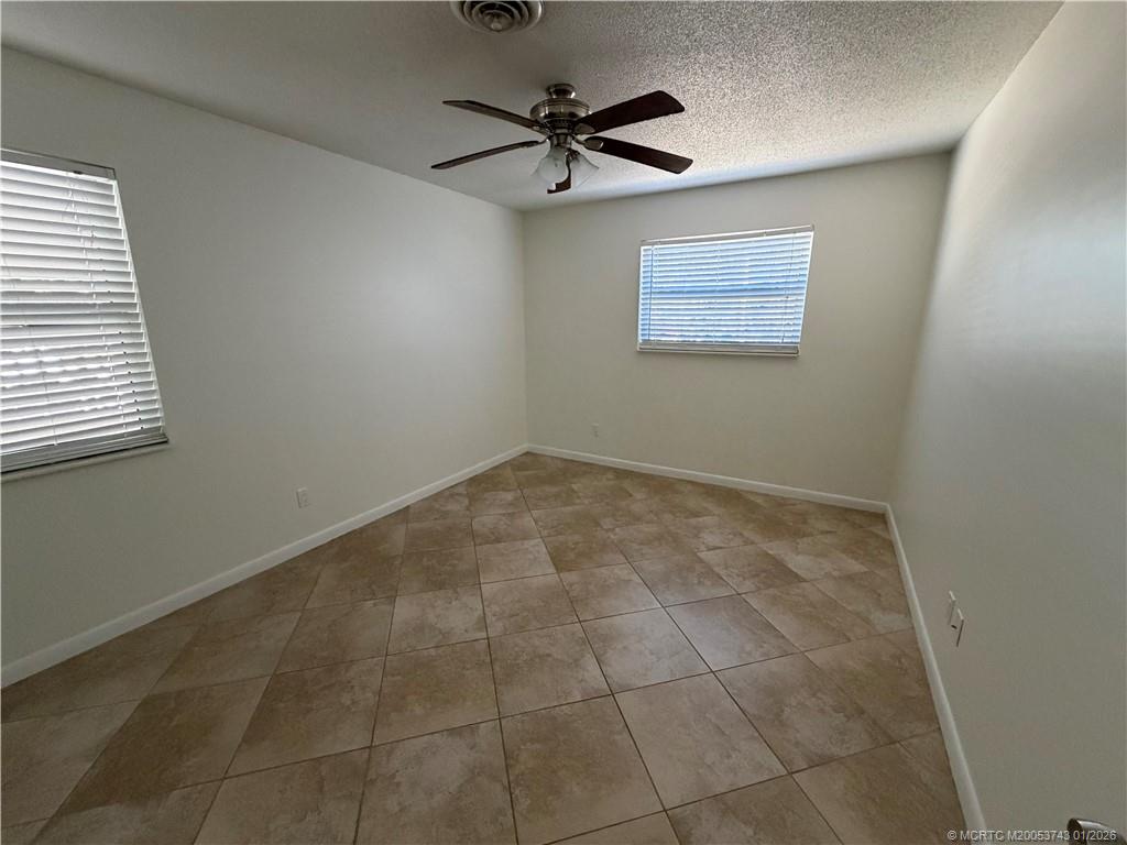 820 Northwest 10th Terrace Stuart, FL 34994 - Photo 13 of 21 a view of an empty room with a ceiling fan and window