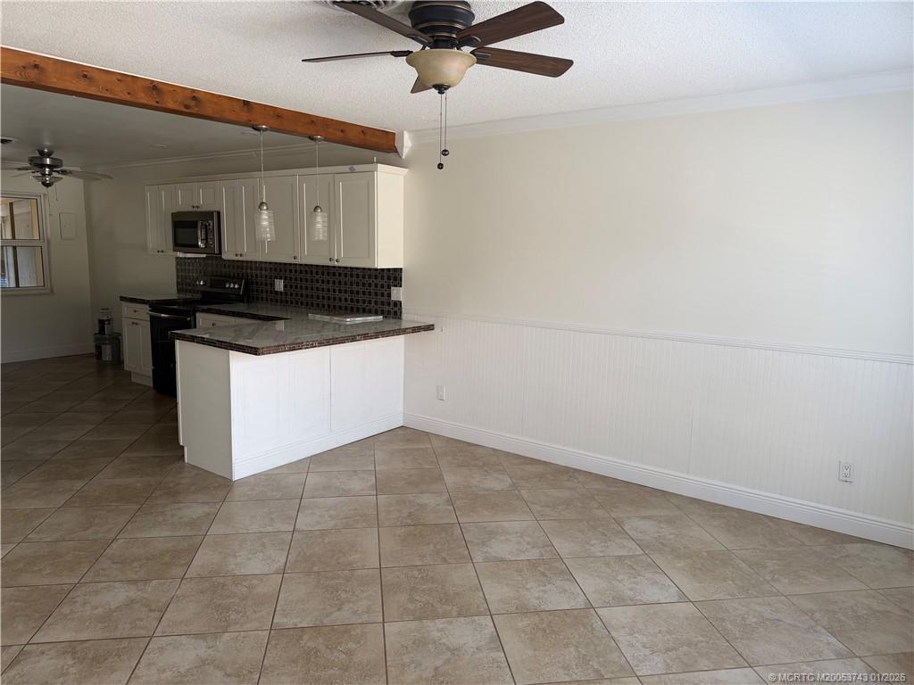 820 Northwest 10th Terrace Stuart, FL 34994 - Photo 16 of 21 a kitchen with granite countertop a stove a sink and a refrigerator