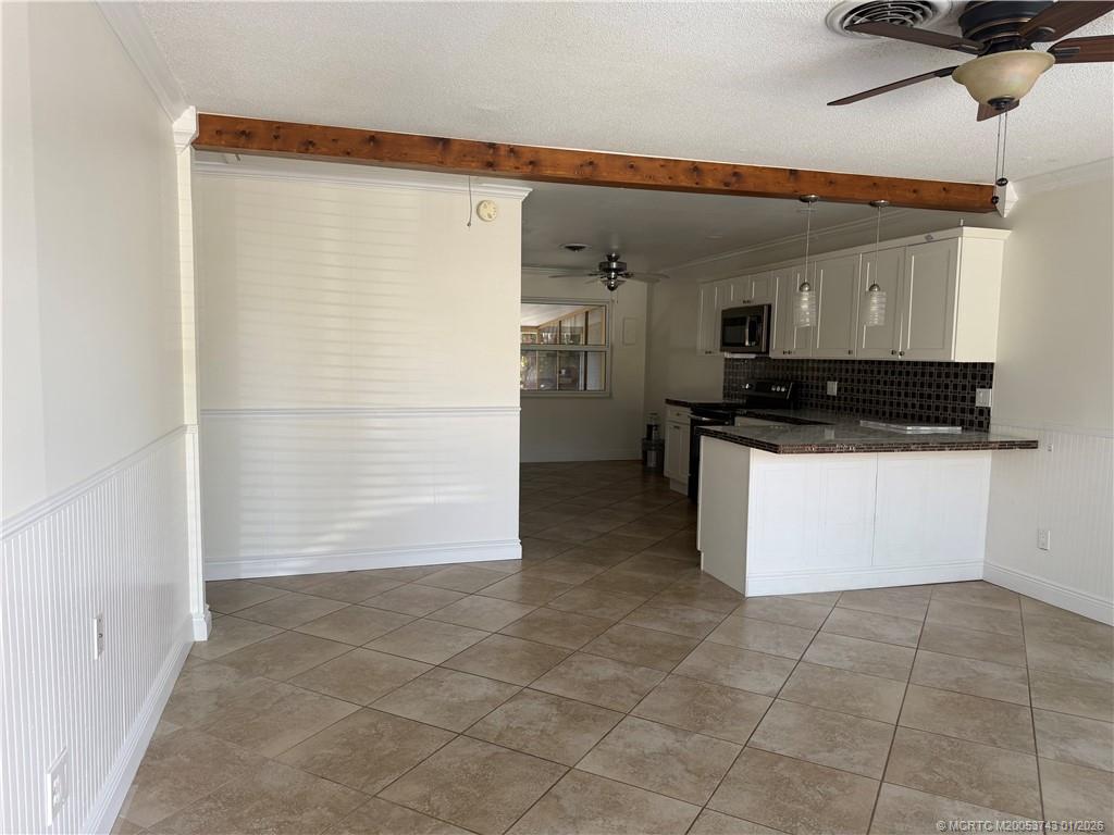 820 Northwest 10th Terrace Stuart, FL 34994 - Photo 17 of 21 a kitchen with granite countertop a stove a sink and a refrigerator