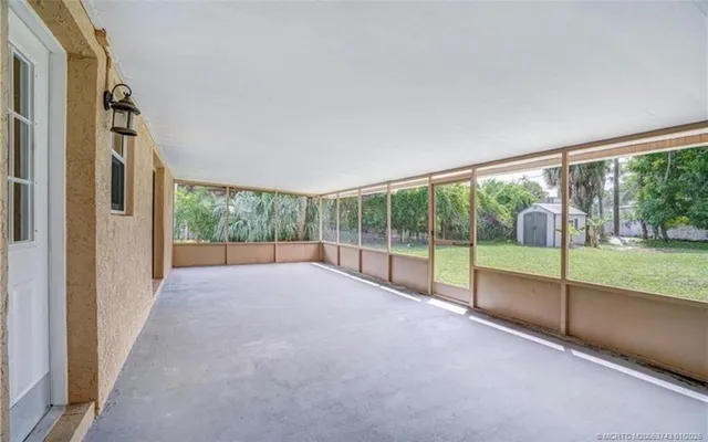 a view of an empty room with wooden floor and a fireplace