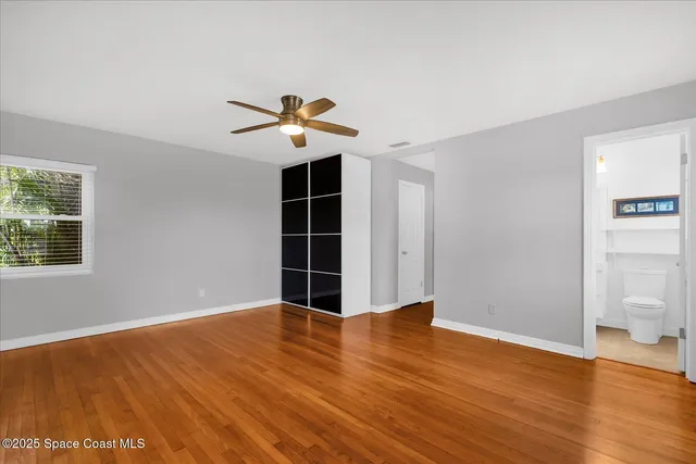 a view of a big room with wooden floor and windows