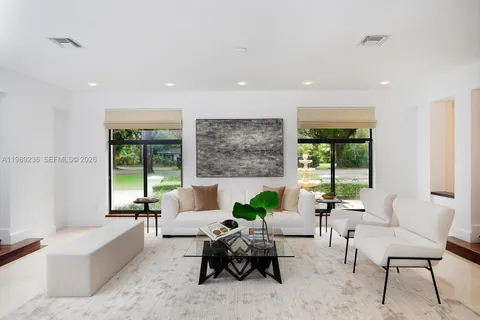 a living room with furniture and large windows