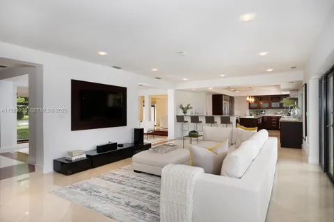 a living room with furniture and view of kitchen