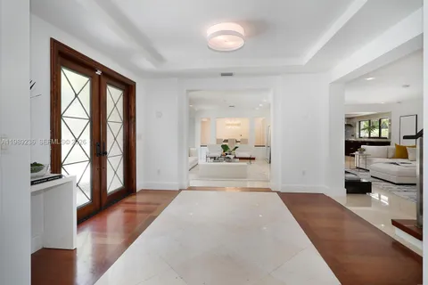 a living room with furniture floor to ceiling window and a flat screen tv