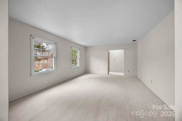 an empty room with windows and closet