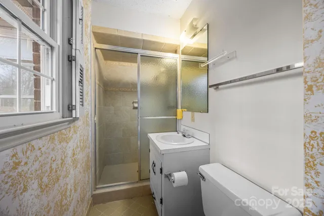 a bathroom with a shower a toilet and a sink