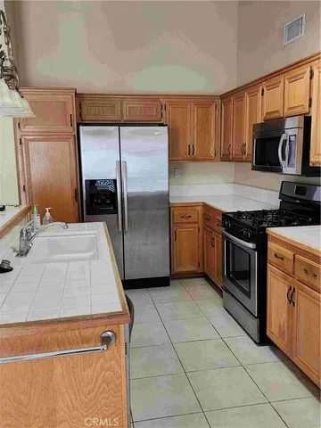 a kitchen with stainless steel appliances granite countertop a stove a sink and a refrigerator